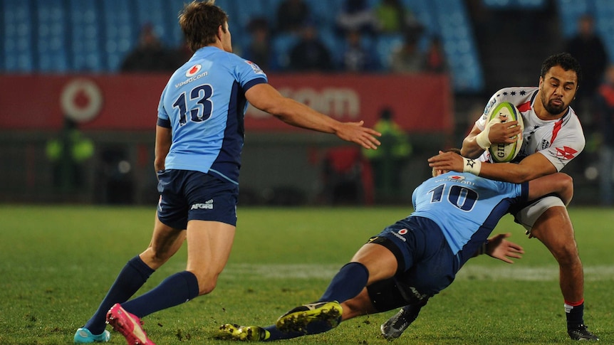 The Rebels' Telusa Veainu (R) is tackled by the Bulls defence at Loftus Versfeld on July 11, 2014.