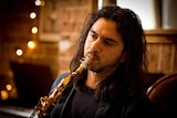 Ariel Azzimonti practices playing saxophone at his home in Sydney.