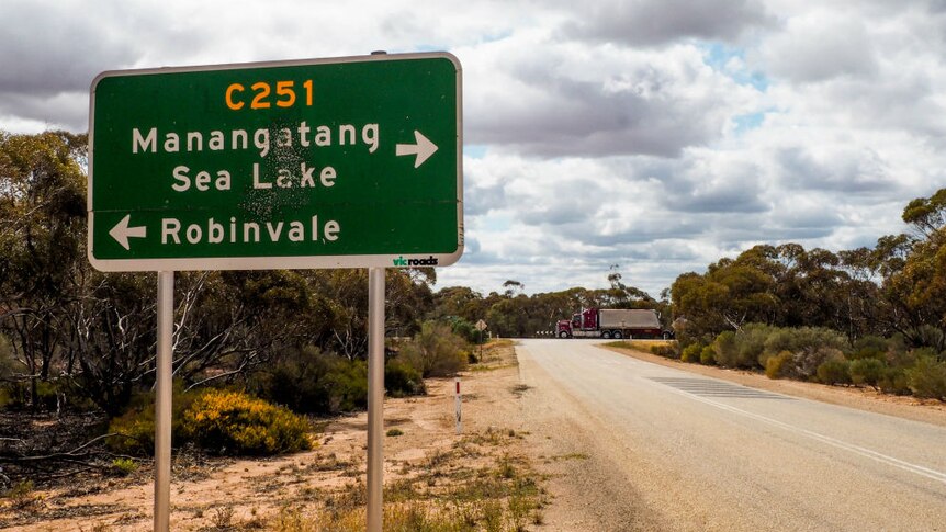 The C251 Robinvale-Sea Lake road sign with a truck driving in the background.