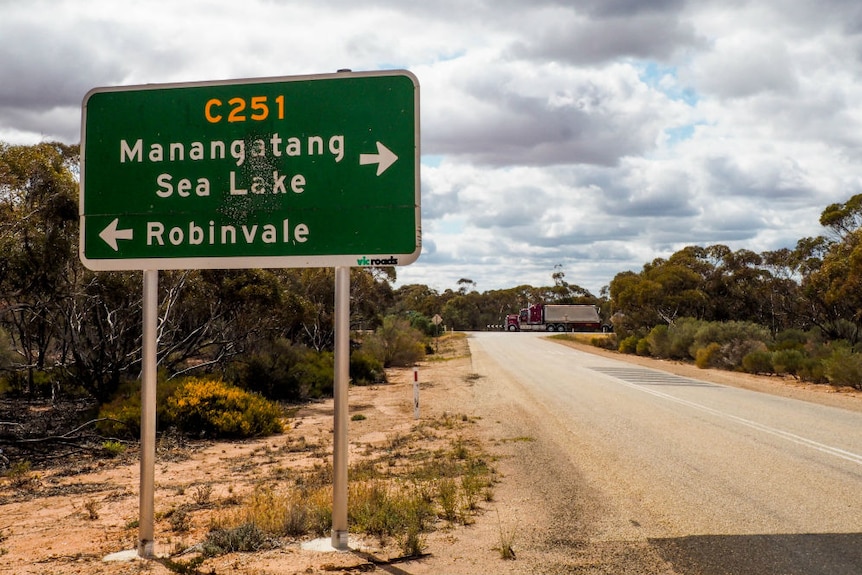 The C251 Robinvale-Sea Lake road sign with a truck driving in the background.