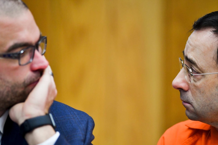 Larry Nassar looks up at his attorney Matt Newburg in Eaton County Circuit Court in Charlotte