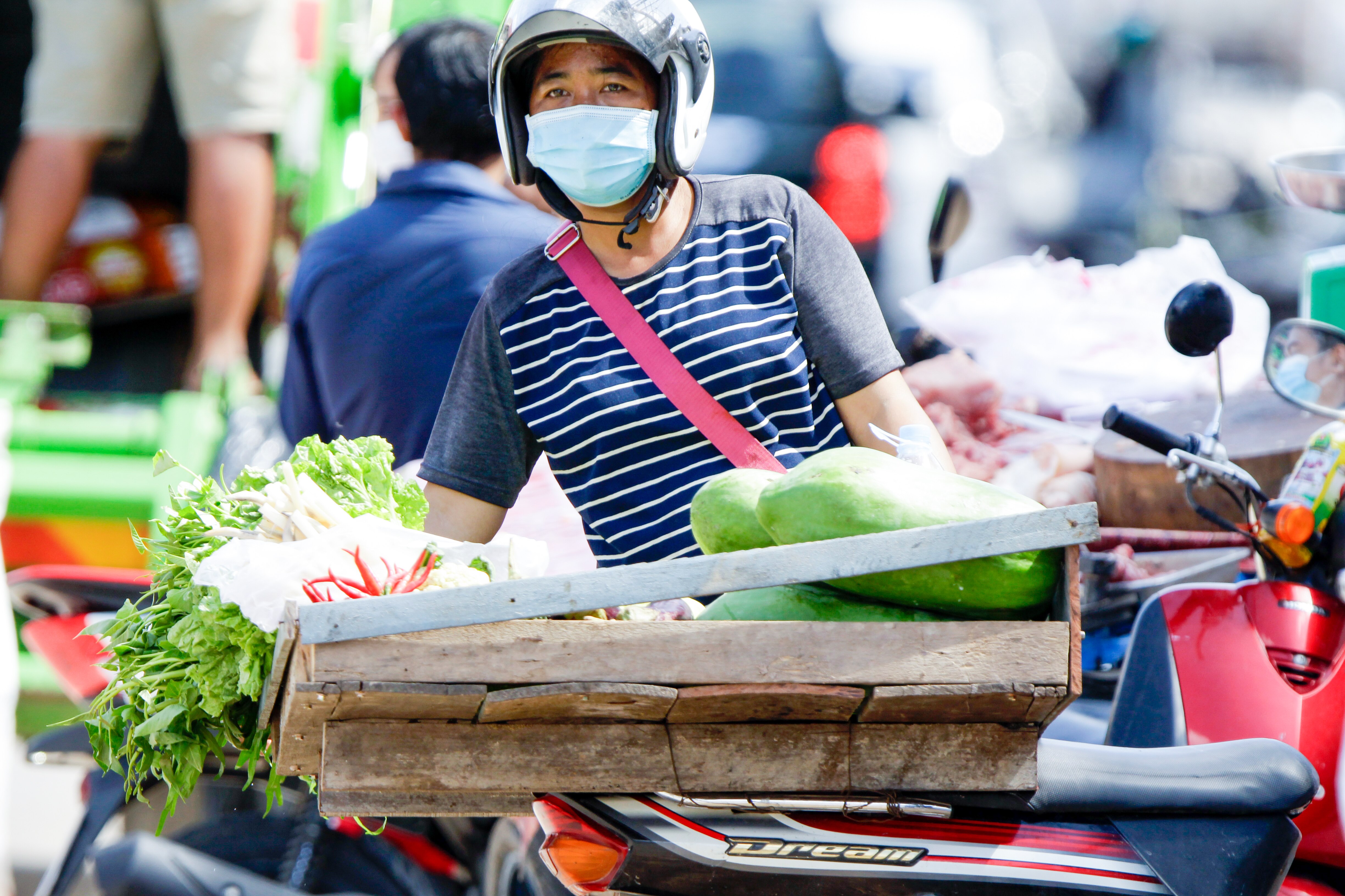A man in a helmet and face mask with a tray of vegetables