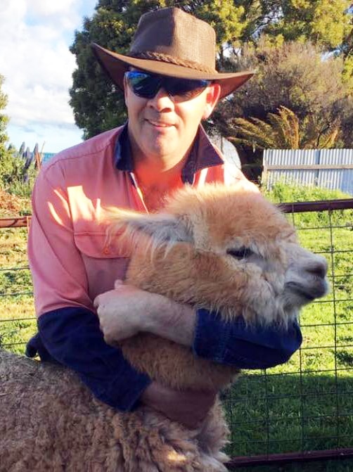 Warwick Clark hugs Trixie the alpaca