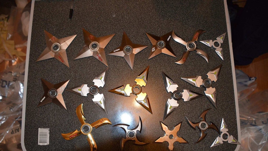 More than a dozen throwing stars are laid out next to each other