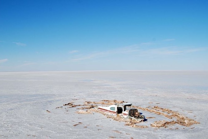 The wreckage of a light plane lies embedded in the surface of Lake Eyre