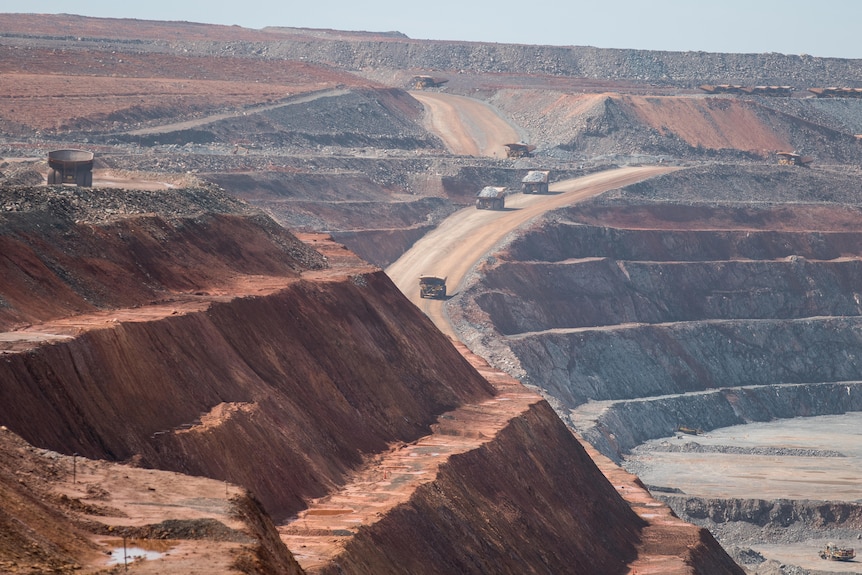 Camions de transport minier travaillant dans une mine à ciel ouvert.  