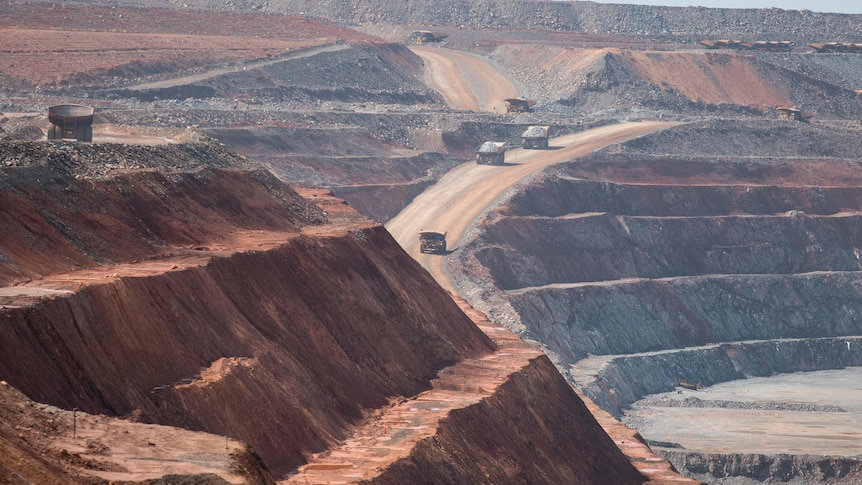 Mining haul trucks operating inside an open cut gold mine.  