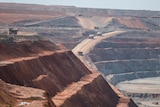 Mining haul trucks operating inside an open cut gold mine.  