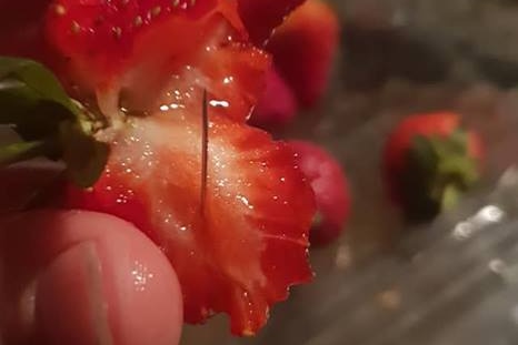 A needle sticking out of a strawberry purchased by Chantal Faugras.