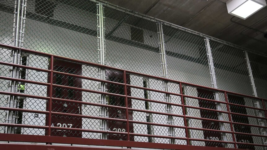 A wire gate blocks off cells at Guantanamo.