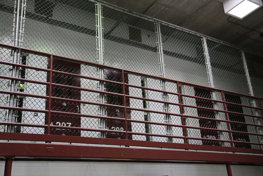 A wire gate blocks off cells at Guantanamo.