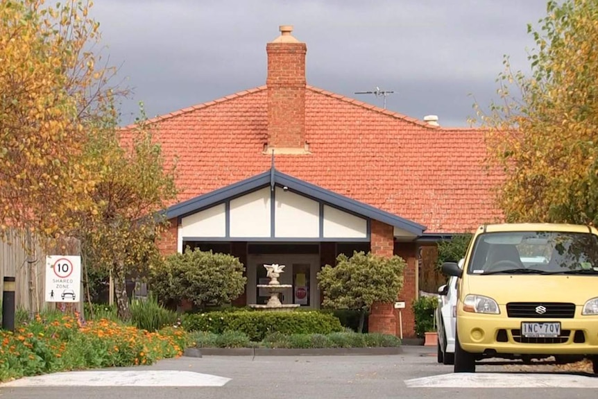 The driveway leading to an aged care centre in a converted red brick building.