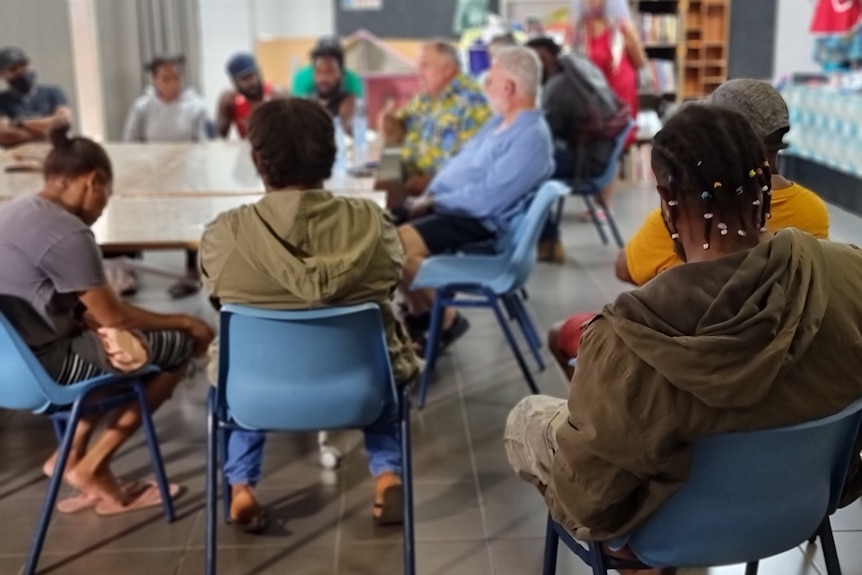 A group of workers sitting down with their back's to the camera