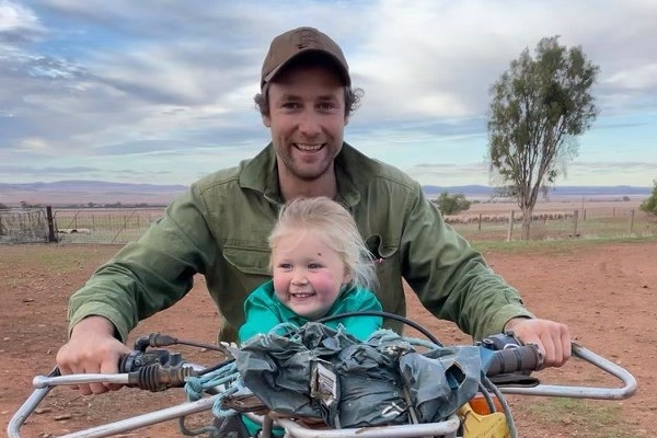 Sheep farmer Sam Kuerschner on a dirt bike with his daughter.