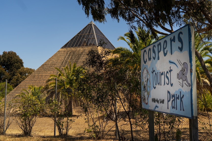 A sign saying caspers tourist park in front of a large pyramid made out of concrete.