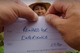 A pair of hands prepares to tear up a piece of paper labelled "reward for experience".