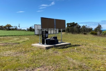 A environmental monitoring station installed in a grassy field on the hillside site. 