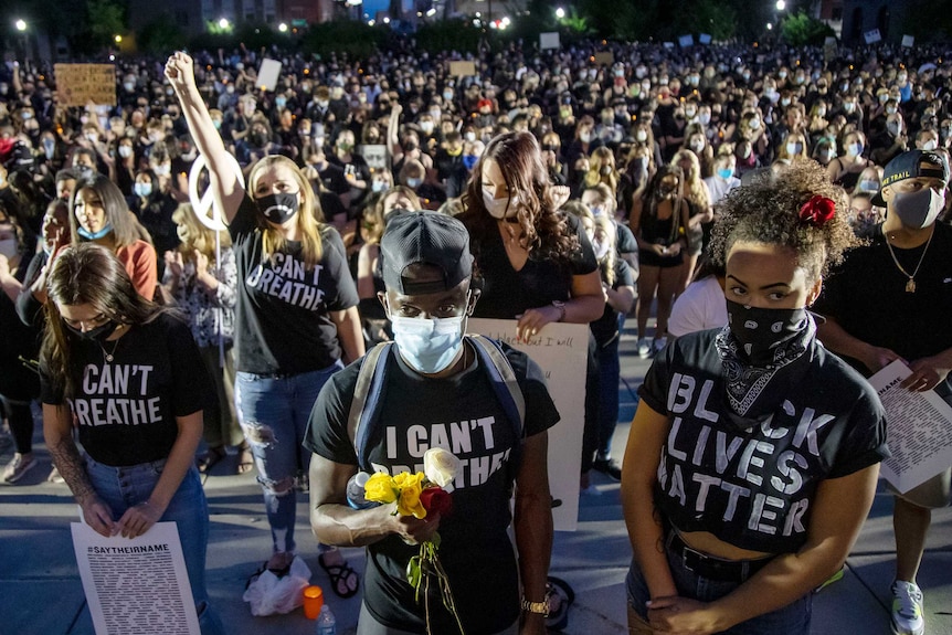 Young people in t-shirts reading 'I can't breathe' standing in a mass vigil