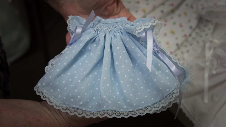 Woman holds a tiny wee care gown