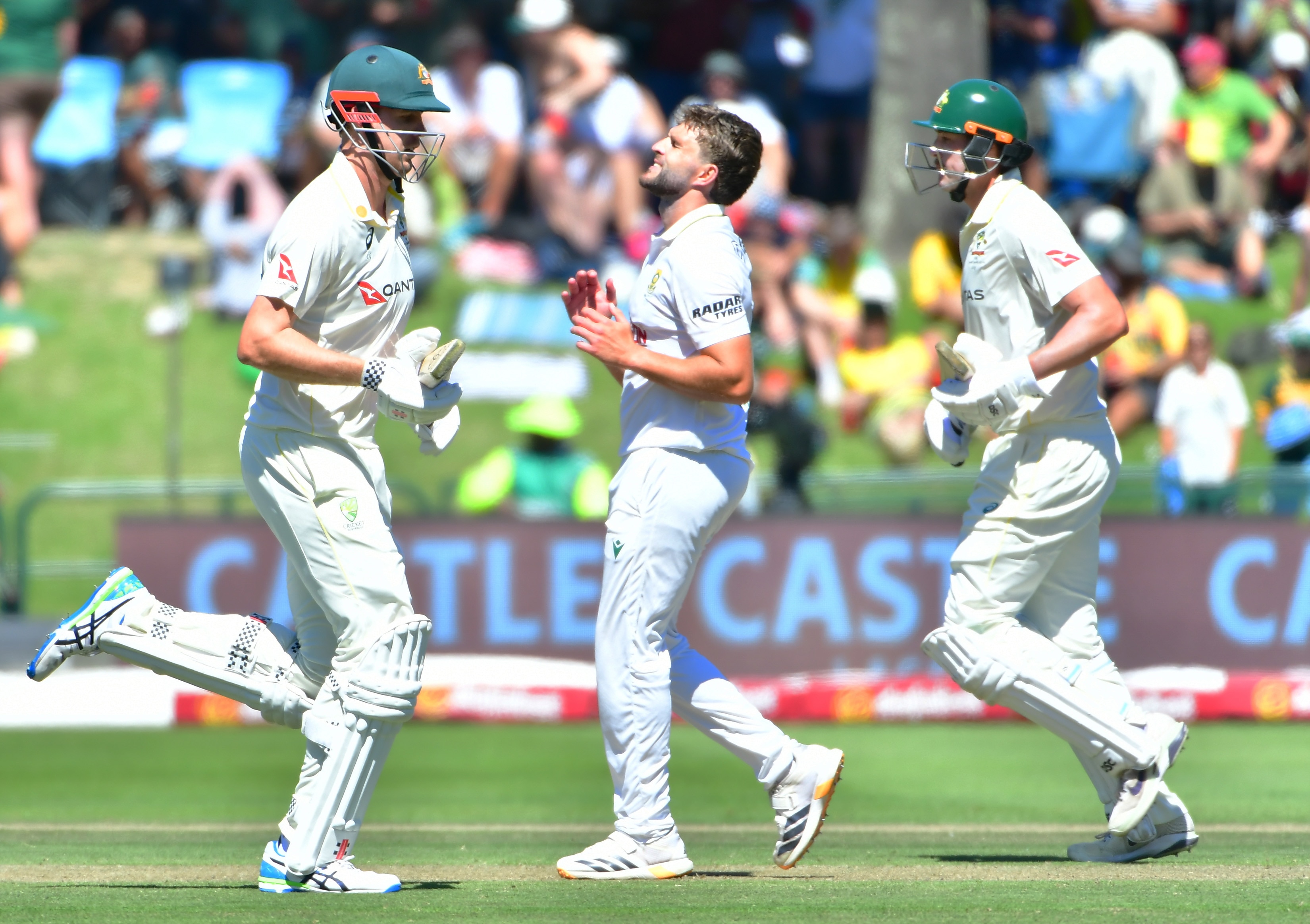 Australia batters Cameron green and Matt Renshaw run between wickets with South Africa bowler Wiaan Mulder between them.