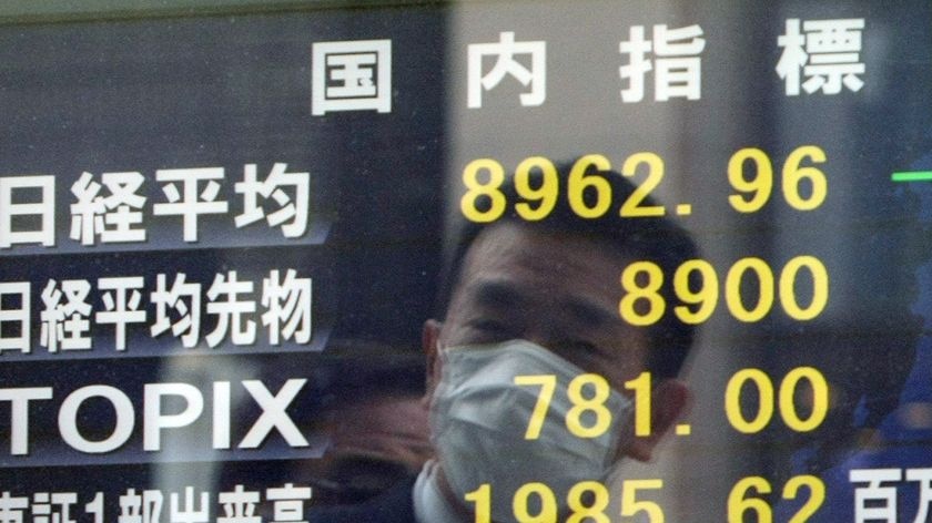 A Japanese businessman watches share prices fall (AFP/Jiji Press)