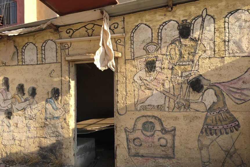 Vandalism of a Christian mural, blacked out faces of the depicted people