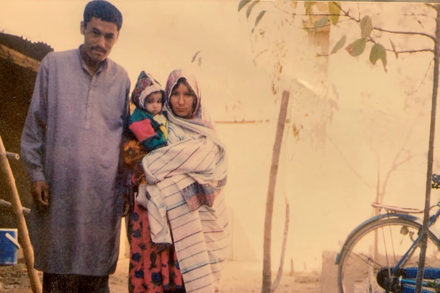 An old photo of a man and woman with a baby