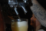 A barwoman pours a beer in a Darwin hotel.