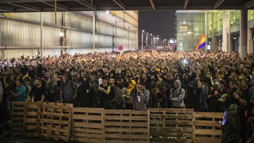 Protestors make a barricade during clashes with police outside El Prat airport in Barcelona, Spain.