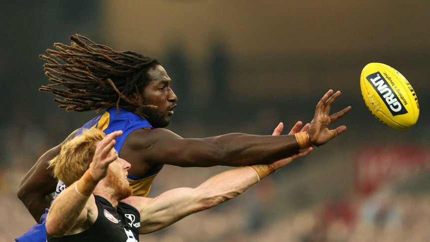 West Coast's Nic Naitanui reaches for the ball ahead of Andrew Philips of Carlton