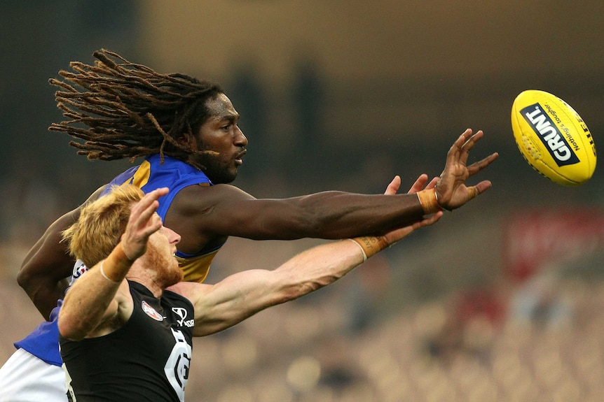 West Coast Eagles ruckman Nic Naitanui reaches for the ball ahead of Andrew Philips of Carlton