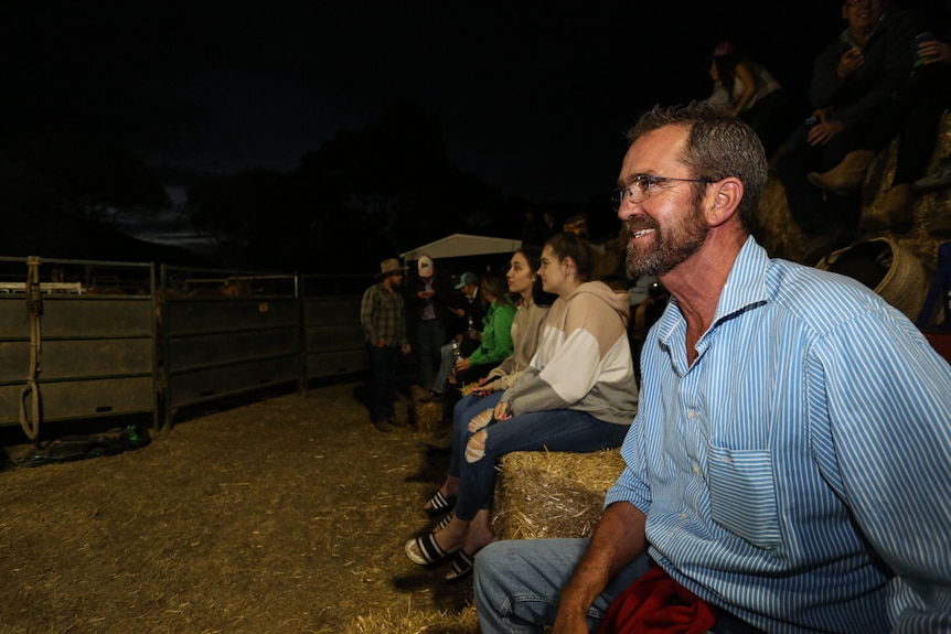 Sheep farmer and close friend David Fenton sitting on hay bales at the Rodeo in Dunkeld.