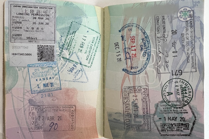An open passport with a variety of stamps covering the pages.