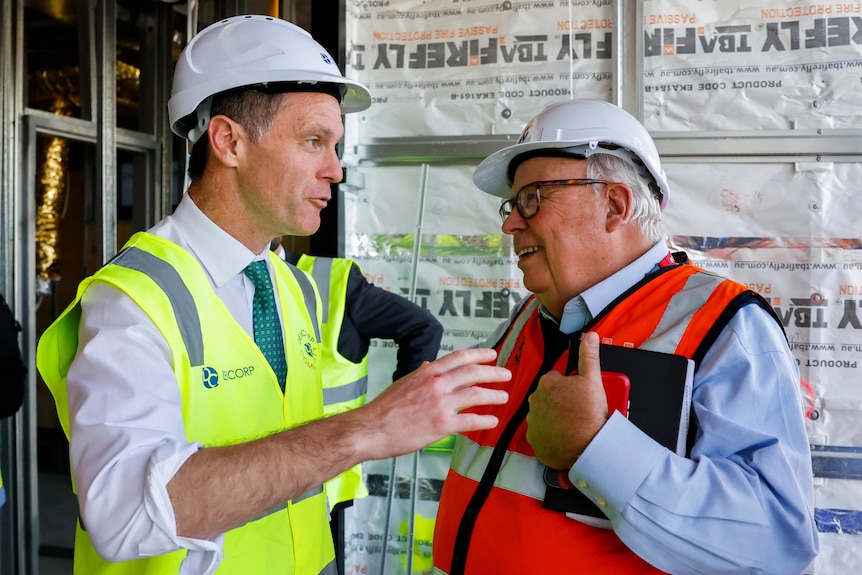 El primer ministro de Nueva Gales del Sur, Chris Minns, habla con el comisionado de construcción de Nueva Gales del Sur, David Chandler, el martes 16 de mayo.