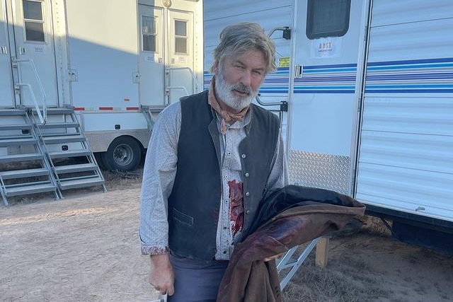 A photo of Alec Baldwin dressed as a cowboy with prop blood on his costume for the movie Rust.