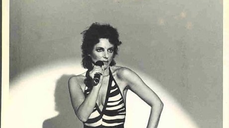 a black and white image of Jeannie Lewis holding a microphone during a performance