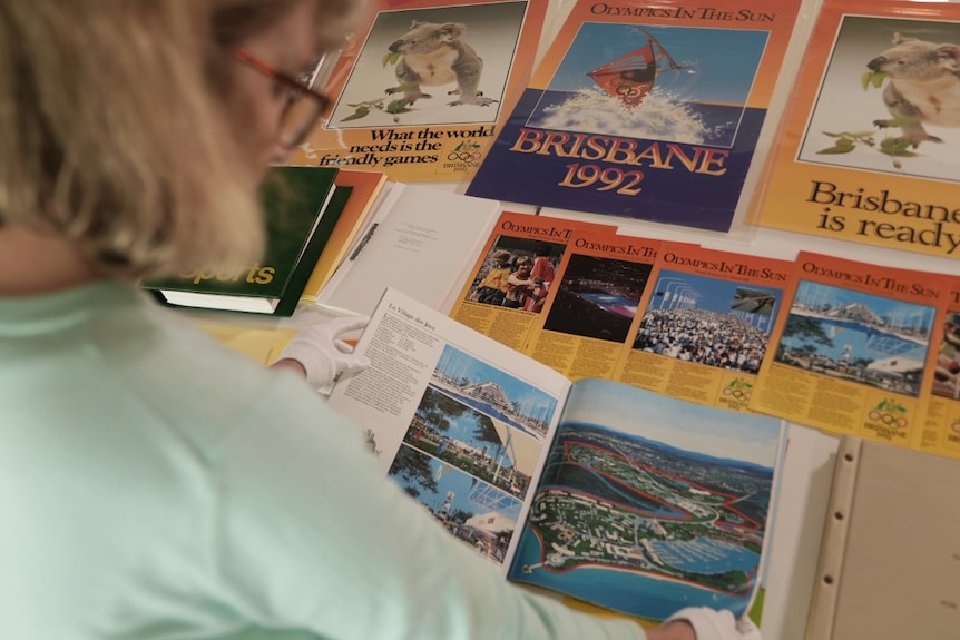 A woman looks over papers about a 1992 olympic bid in Brisbane.