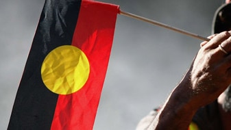 Man holding an Indigenous flag (Getty Images: Simon Fergusson)