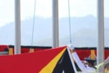 The East Timorese flag is officially hoisted to the top of a flagpole in Dili.