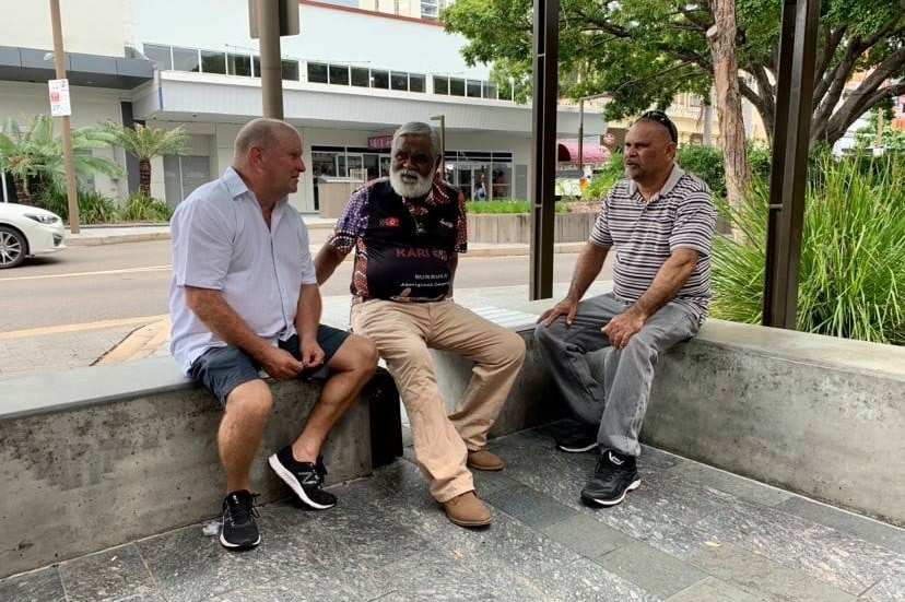 Group of men sitting on a stool on the street