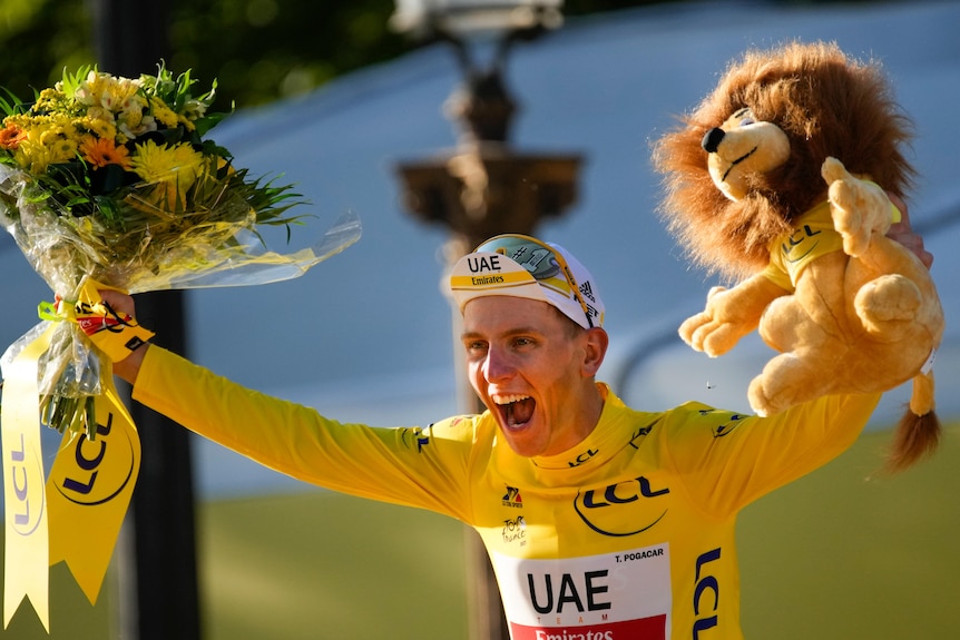 Tour de France winner Slovenia's Tadej Pogacar, wearing the overall leader's yellow jersey, celebrates on the podium.