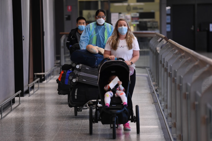 Passangers wearing face masks exit an airport tunnel