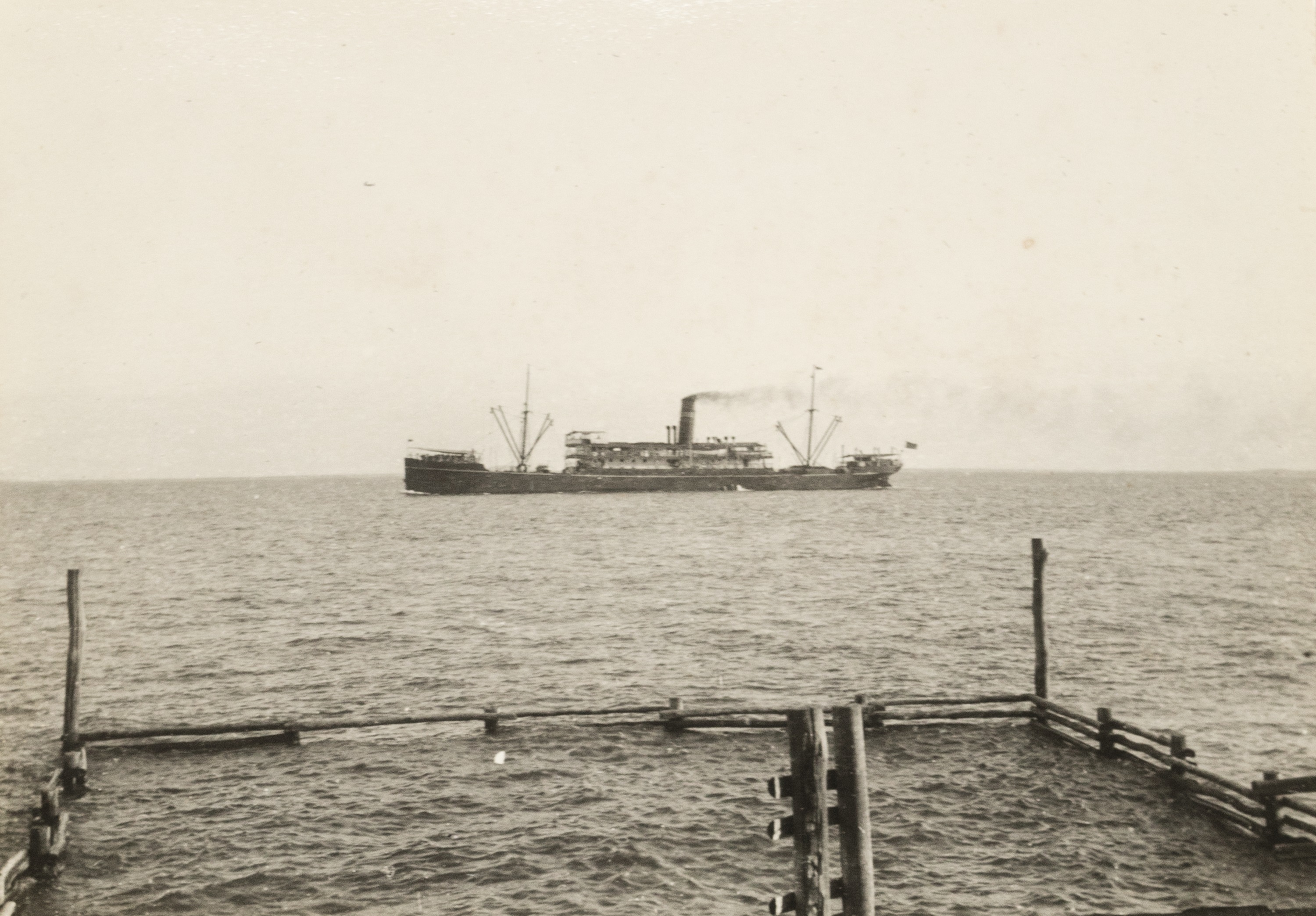 SS Mataram 船的历史黑白照片在达尔文港的岸边。” class=