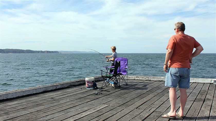 An image of a man and his son fishing from a jetty at Tathra