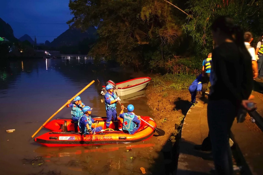 Rescuers are seen preparing to search for missing people in the river.