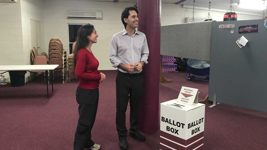 Acting Fraser Coast Regional Council Mayor George Seymour stands with his wife next to ballot box at Hervey Bay PCYC.