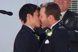 Ivan Hinton and his husband Chris Teoh kiss during their wedding in Canberra.