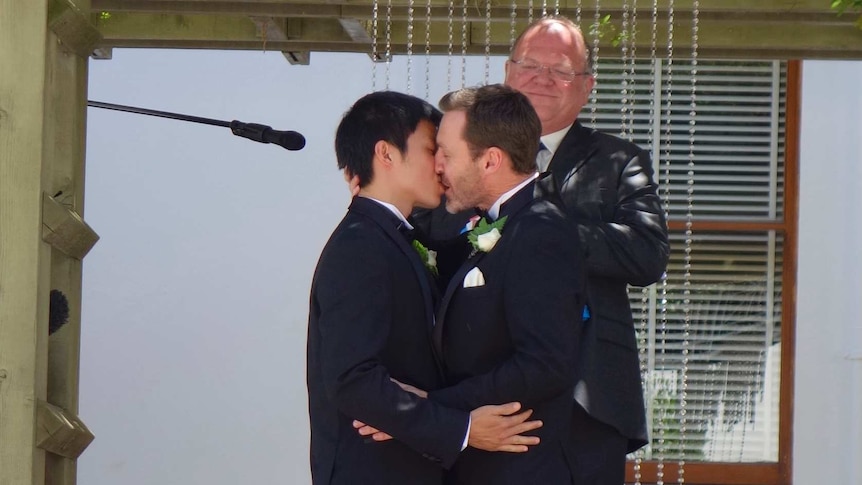 Ivan Hinton and his husband Chris Teoh kiss during their wedding in Canberra.