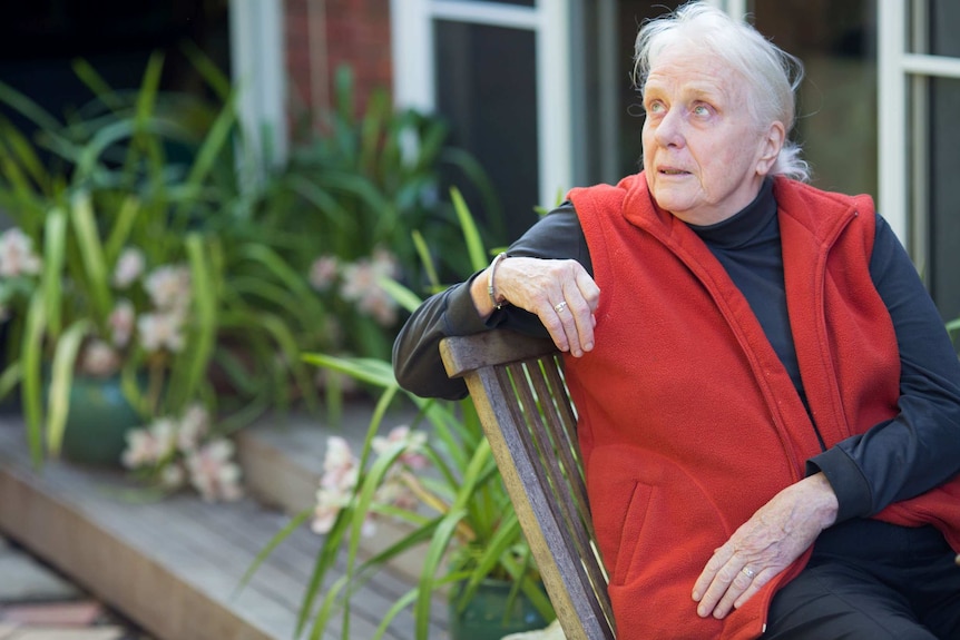 Hilary looks upwards as she sits on a chair in her garden.