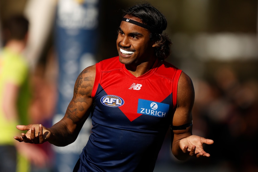 A Melbourne Demons AFL player celebrates a goal against Port Adelaide.